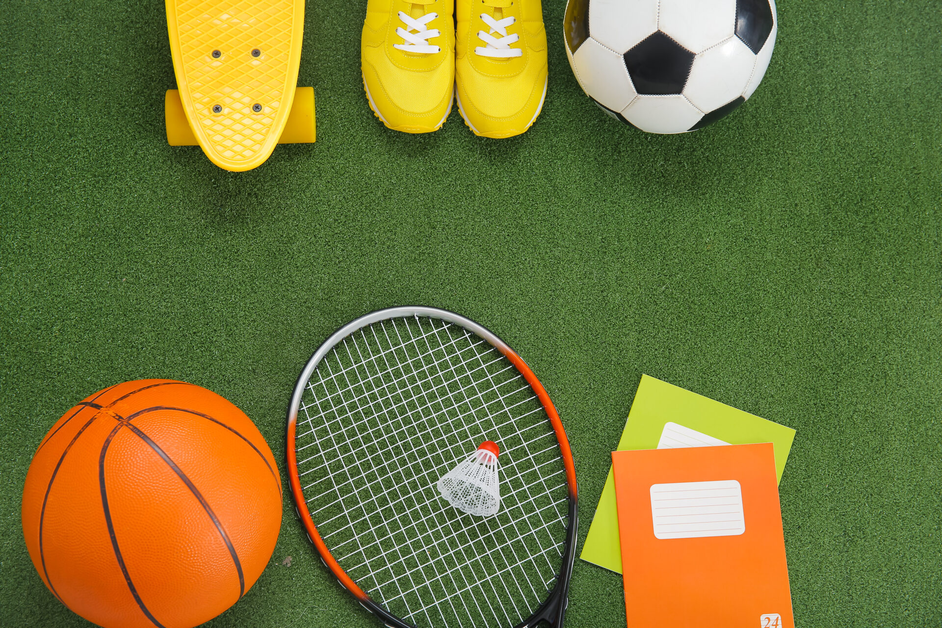 Sport equipment with sneakers and notebooks on color background