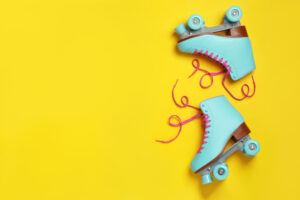 Pair of stylish quad roller skates on color background, top view with space for text