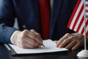 Middle Aged Male Politician Signing Document during Business Meeting